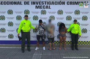 En la fotografía se aprecia a Jaime David Bolaños Vargas y Valentina Zambrano Bolaños, de pie, con los brazos atrás y con la cabeza agachada. La mujer viste un top y short de color gris; asimismo, pantuflas. El hombre viste camiseta de manga corta clara con letras grandes en color negro, pantaloneta oscura y zapatillas blancas. Al lado y lado de ellos hay uniformados de la Policía Nacional. Detrás de ellos hay un pendón institucional de la Policía.