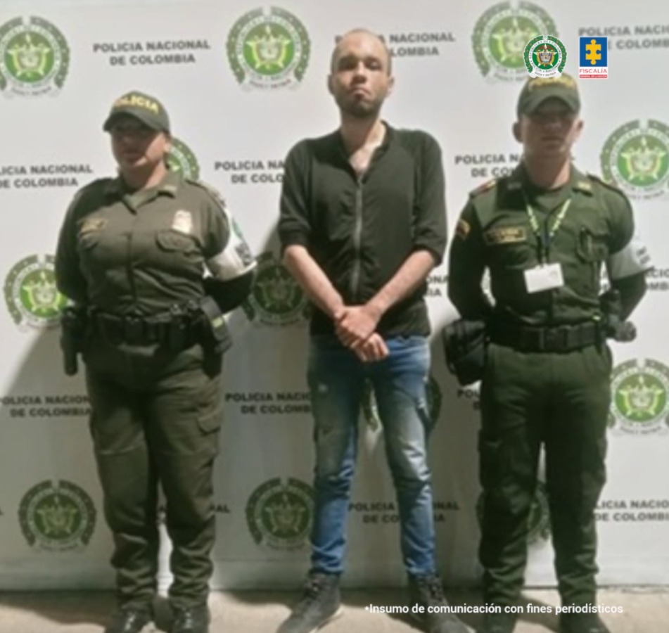 En la fotografía se aprecia de pie y con los brazos adelante a Jerson Steven Barbosa Pineda. Viste buso de color verde y con cierre; jean azul desgastado y botines negros. A sus extremos hay uniformados de la Policía Nacional. Detrás de ellos hay un pendón institucional de la Policía.