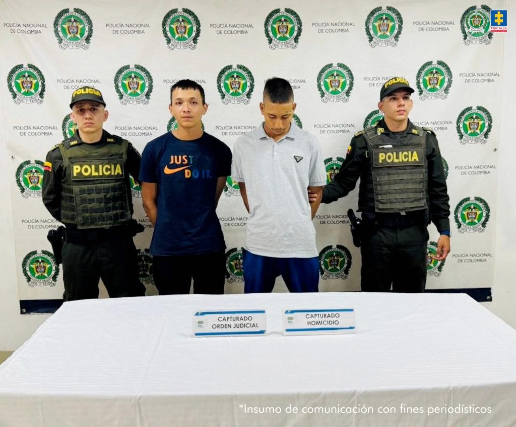 En la fotografía aparecen de pie y con los brazos atrás Jeison Granada Varela y Johan Alberto Romero Varela. Uno viste camiseta de color negro, de manga corta, con estampado naranja en el lado derecho del pecho; así como pantalón negro. El otro viste con camisa de color blanco, de manga corta y cuello y pantalón azul. A los extremos hay uniformados de la Policía Nacional. Delante de ellos hay una superficie de color blanco con dos letreros que dicen: ‘Capturado orden judicial’ y ‘Capturado homicidio’. En la parte posterior hay un pendón institucional de la Policía.