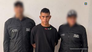 En la imagen aparece una persona de suéter negro entre dos uniformados del CTI de Córdoba. 