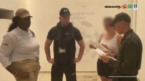 Fiscal Martha Mancera, Martha Mancera, Fiscal Mancera En la fotografía se aprecia de pie y con los brazos en la cintura a Jesse Alexánder Bernard Crilly. Viste camisa y pantaloneta negra, así como una gorra negra. Al lado derecho de él hay una servidora de Migración Colombia y a la izquierda de él hay un uniformado de la Policía Nacional leyendo un documento que tiene en sus manos. Al fondo se aprecia el logo de la Policía de Capurganá.