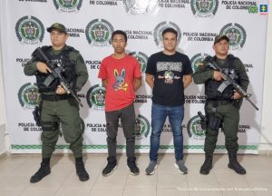 En la fotografía aparecen dos hombres capturados, acompañados de dos uniformados del Gaula de la Policía Nacional. En la parte posterior un banner con logos de la entidad.