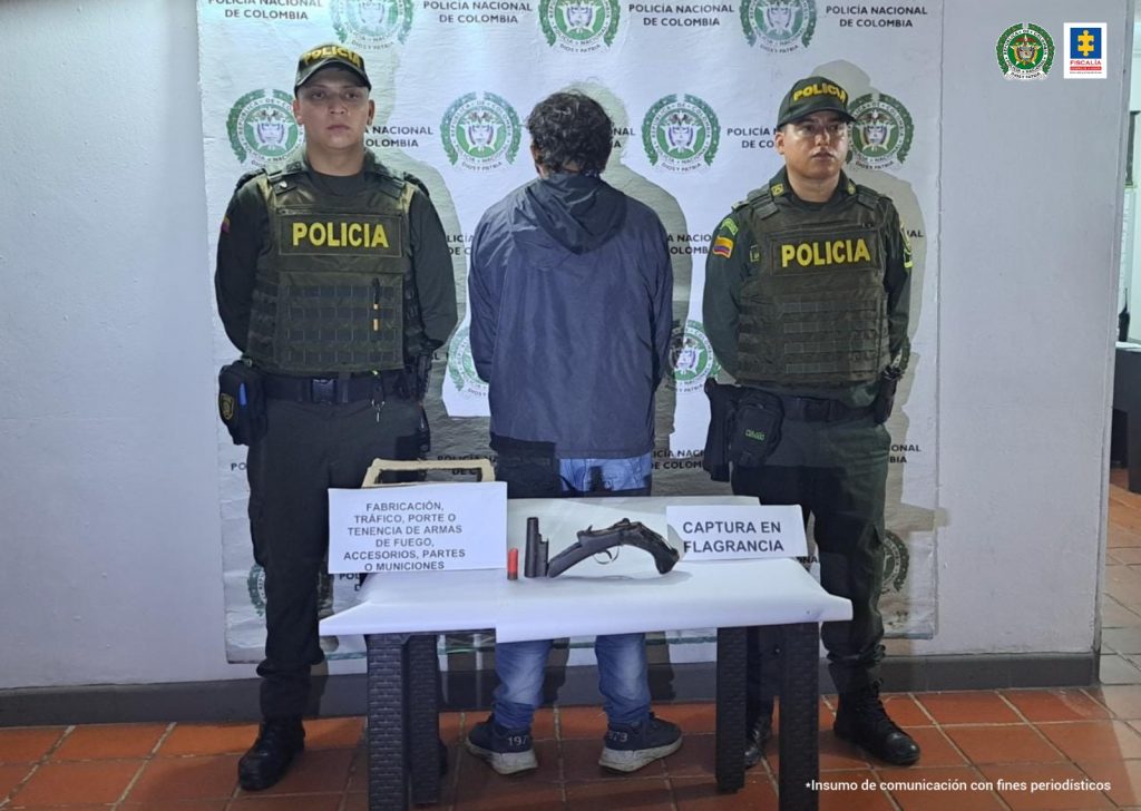 En la fotografía aparecen capturados junto a personal de Fiscalía y Policía Nacional. En la parte posterior de la imagen se ven banners de Policía Nacional y la Fiscalía General de la Nación.