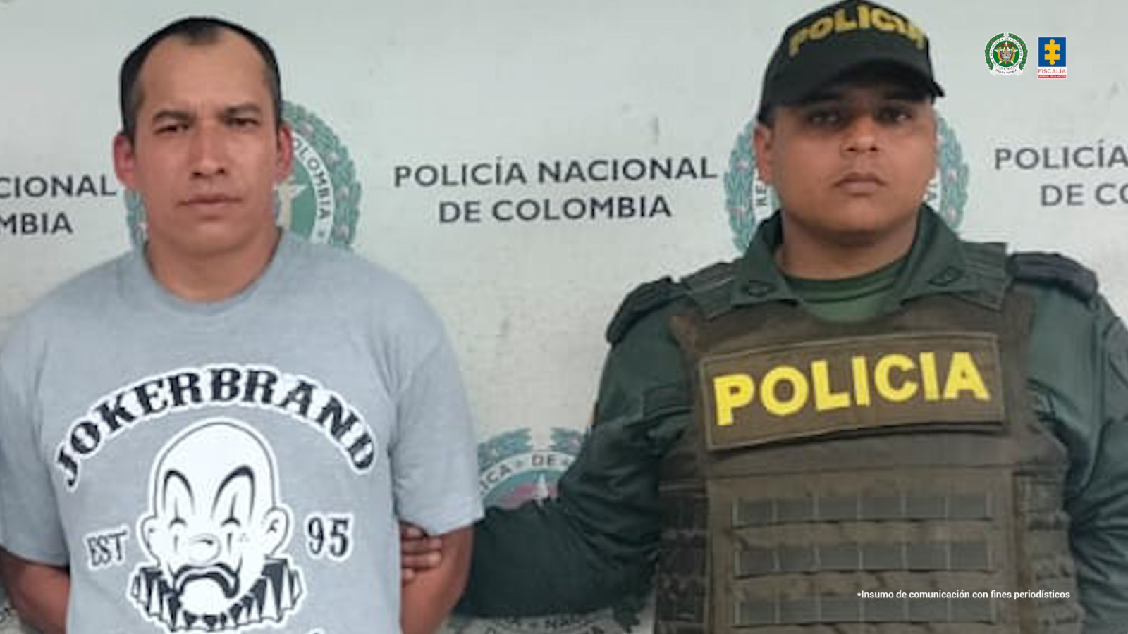 Se observa al capturado de frente y custodiado por un funcionario de Policía Nacional. Atrás, un pendón de Policía Nacional.