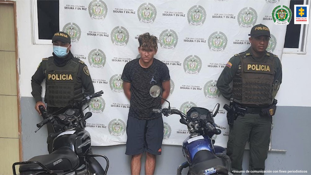 En la imagen se ve una persona capturada, entre dos policías y frente a dos motocicletas incautadas.