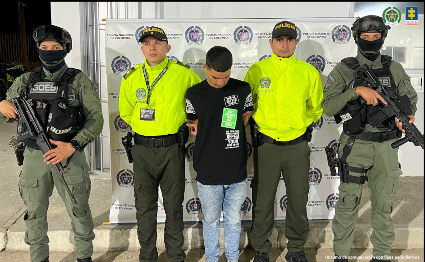 En la imagen aparece una persona de suéter negro, entre cuatro uniformados de la Policía.