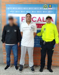 En la imagen está el procesado en medio de un servidor del CTI y otro de la Policía Nacional.