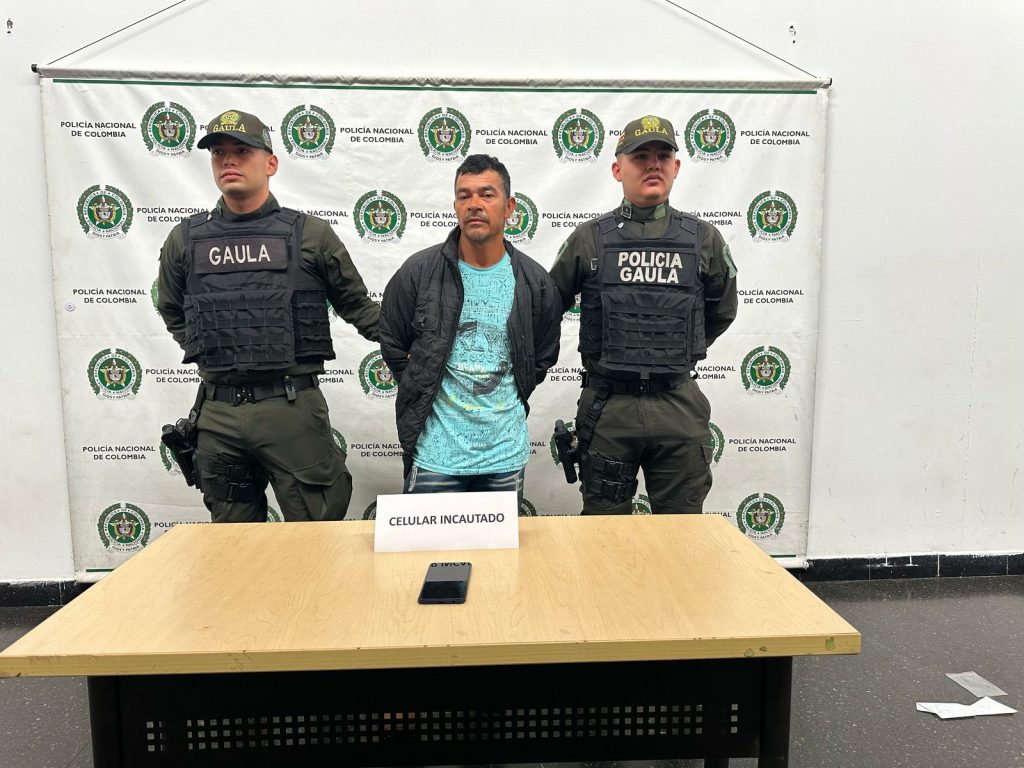 En la imagen está John Alcides Bustamante entre dos servidores del Gaula de la Policía Nacional