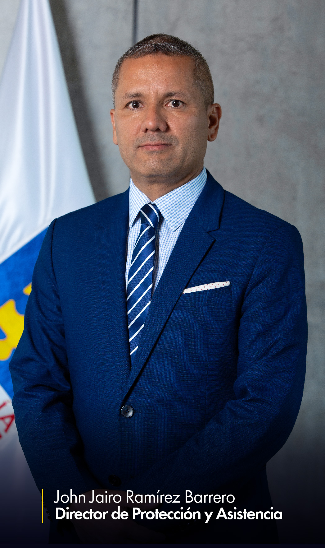 En la imagen aparece John Jairo Ramírez Barrero, director de Protección y Asistencia, en una foto de medio cuerpo. Al fondo puede verse parcialmente una bandera de la Fiscalía.