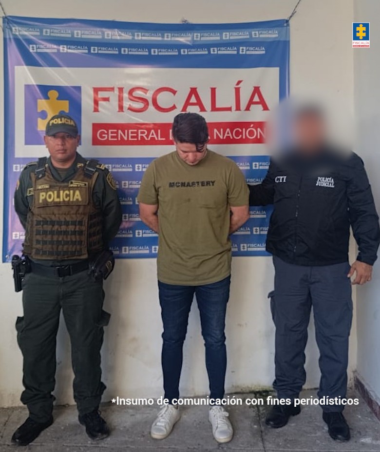 En la imagen aparece una persona de camiseta verde y jean entre dos uniformados de la Policía Nacional y el CTI. 