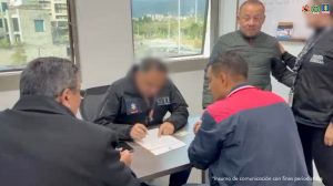 En primer plano, tres hombres están sentados alrededor de una mesa, dos de ellos de espaldas a la cámara y otro al frente, revisando o firmando documentos. Uno de los presentes viste una chaqueta negra con el logo y las siglas CTI – Policía Judicial, lo que indica que pertenece al Cuerpo Técnico de Investigación de la Fiscalía.Al fondo, de pie, se encuentra un hombre mayor con chaqueta verde, acompañado por otra persona con uniforme de Policía Judicial, quien le sostiene del brazo, lo que sugiere que podría tratarse de un procedimiento de captura o reseña. En la parte superior derecha se aprecian los logotipos institucionales de la Fiscalía General de la Nación, la Policía Nacional y otra entidad estatal. En la parte inferior se lee la leyenda: “Insumo de comunicación con fines periodísticos”.