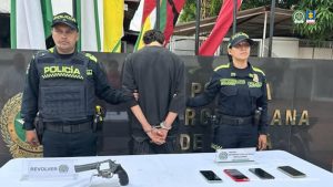 En la foto se observa a la pareja custodiada por dos uniformados de la Policía Nacional. También se observa detrás un backing de la Policía Nacional.