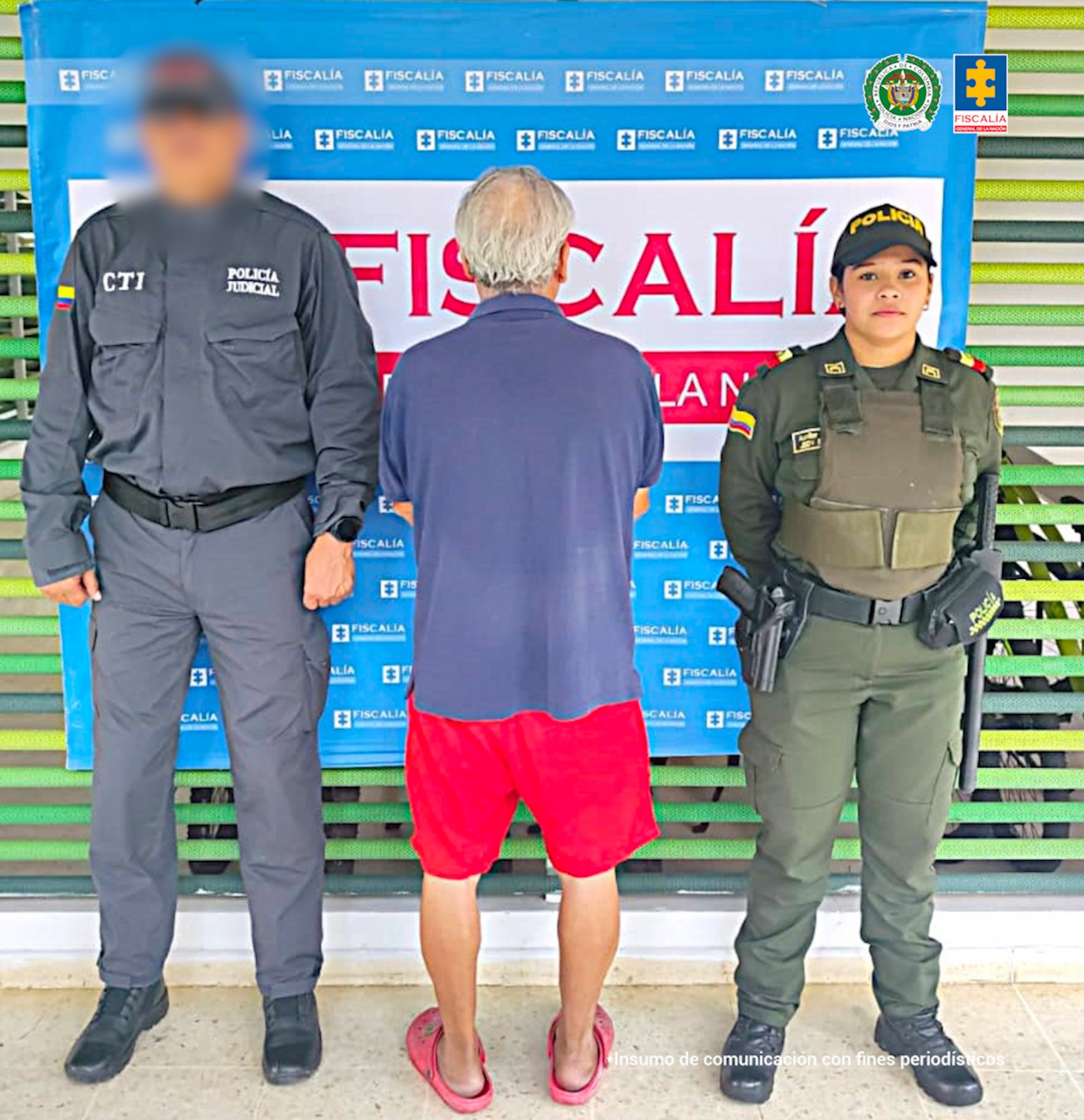 El capturado aparece de espalda a la cámara, esposado y custodiado por un servidor del CTI de la Fiscalía y una uniformada de la Policía Nacional.