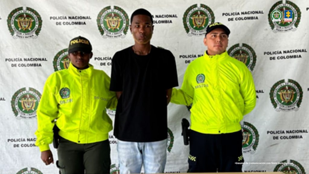 En la fotografía se aprecia de pie y con los brazos atrás a José Antonio Cundumí Mosquera. Viste camiseta de manga corta de color negro; jean azul desgastado. A los extremos de él hay uniformados de la Policía Nacional. Delante de ellos hay una mesa y sobre ella un letrero que dice: ‘Orden judicial’. Detrás de ellos hay un pendón de la Policía Nacional.