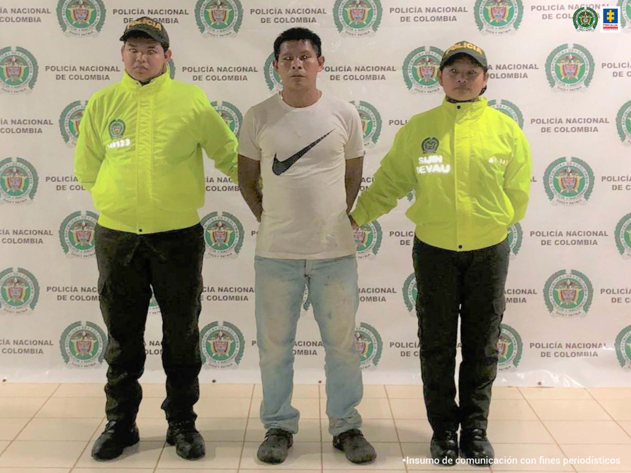 El capturado está custodiado por dos miembros de la Policía Nacional y con las manos esposadas a su espalda.