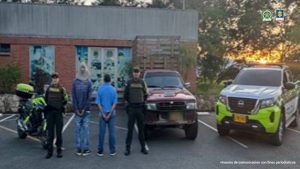 En la fotografía, tomada en exterior, se aprecian de pie, con los brazos atrás y esposados a José Luis Patiño Valencia y Carlo Ariel Quevedo Álvarez. Uno de ellos viste con camisa de manga larga, color azul; jean azul, zapatillas negras con blanco y usa en la cabez una pava de color caqui. La otra persona usa camisa de manda larga recogida hasta los codos, de color azul; jean azul y zapatillas negras con blanco. A los extremos de ellos hay uniformados de la Policía Nacional. A los extremos se aprecia una camioneta de estacas, de color rojo.