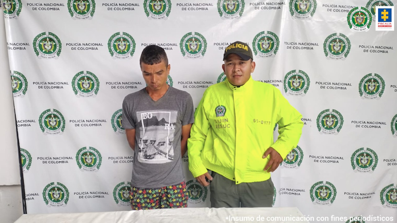 En la imagen se ve una persona detenida junto a un uniformado de la Policía.