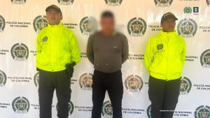 En la imagen se ve al capturado con buzo color gris, un pantalón negro en custodia por dos uniformados de la Policía Nacional.