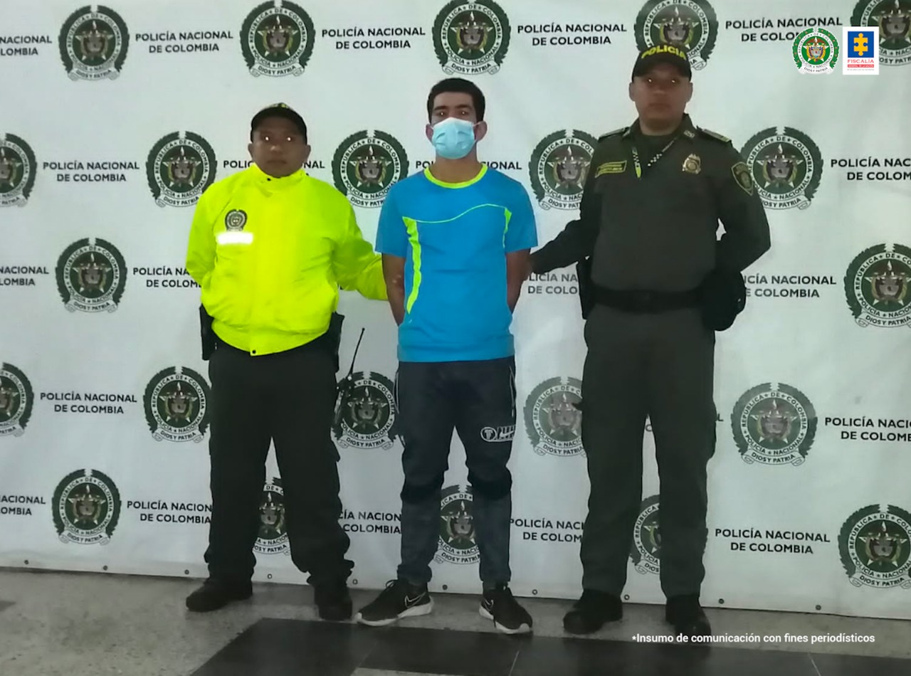 En la imagen se encuetra el procesado con tapabocas y dos servidores de la Policía Nacional a los lados 
