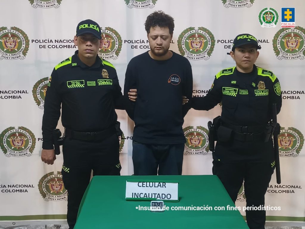 En la imagen está el investigado en medio de dos uniformados de la Policía Nacional