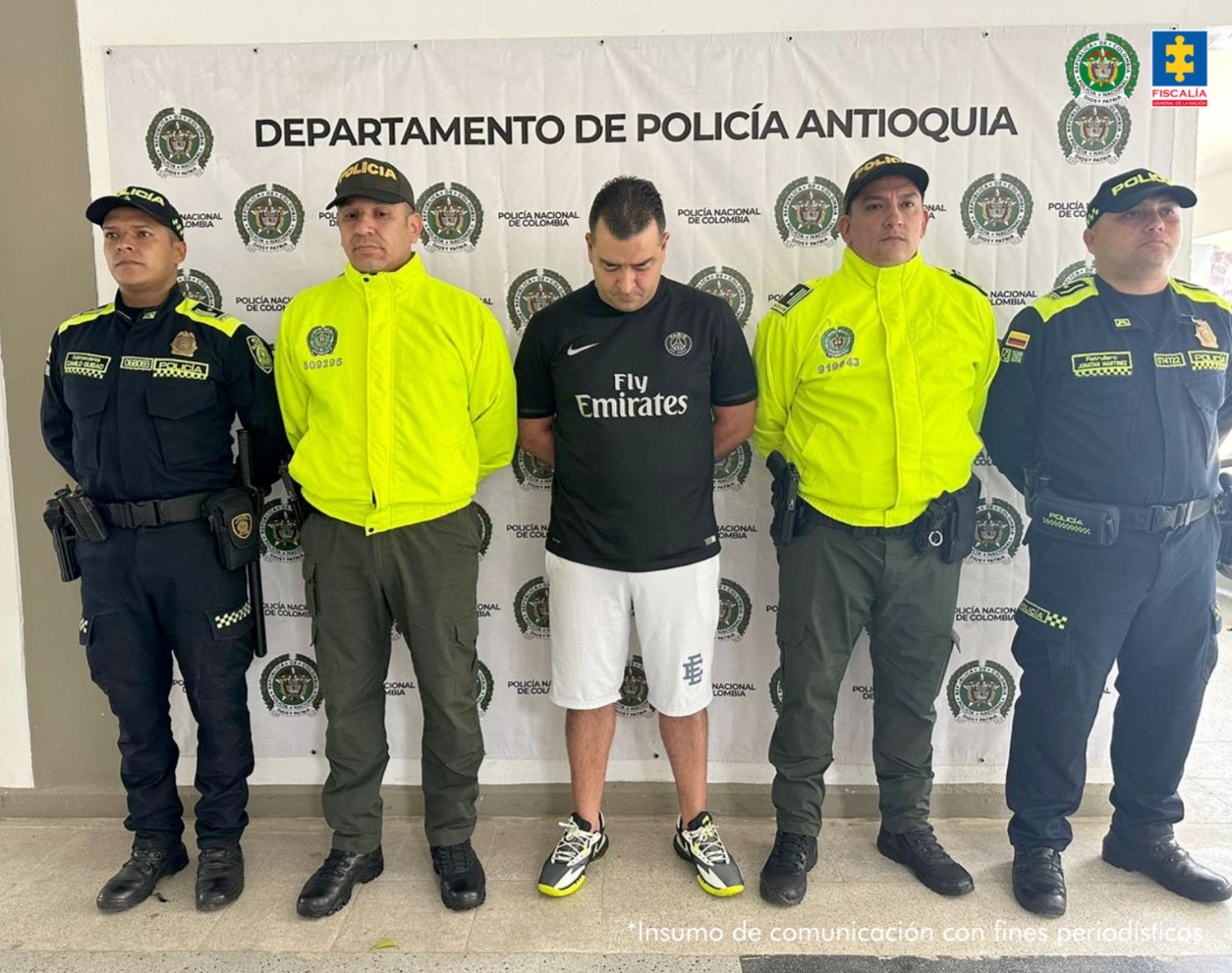 En la imagen está el presunto cabecilla con cuatro servidores de la Policía Nacional a los lados, dos visten uniforme con chaqueta verde fluorescente y dos uniforme azul.