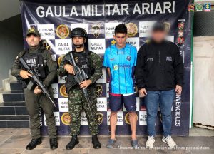 El capturado aparece junto a miembros del Ejército y del CTI, de pie, frente a un banner del Ejército.