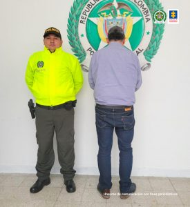 En la fotografía está el procesado de espaldas con un servidor de la Policía Nacional.