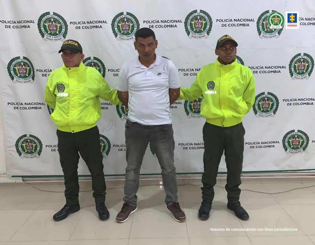 En la imagen se ve una persona detenida entre dos uniformados de la Policía.