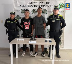 En la fotografía aparecen los dos capturados junto a dos uniformados de la Policía Nacional. En la parte superior está un banner de la Policía Nacional.