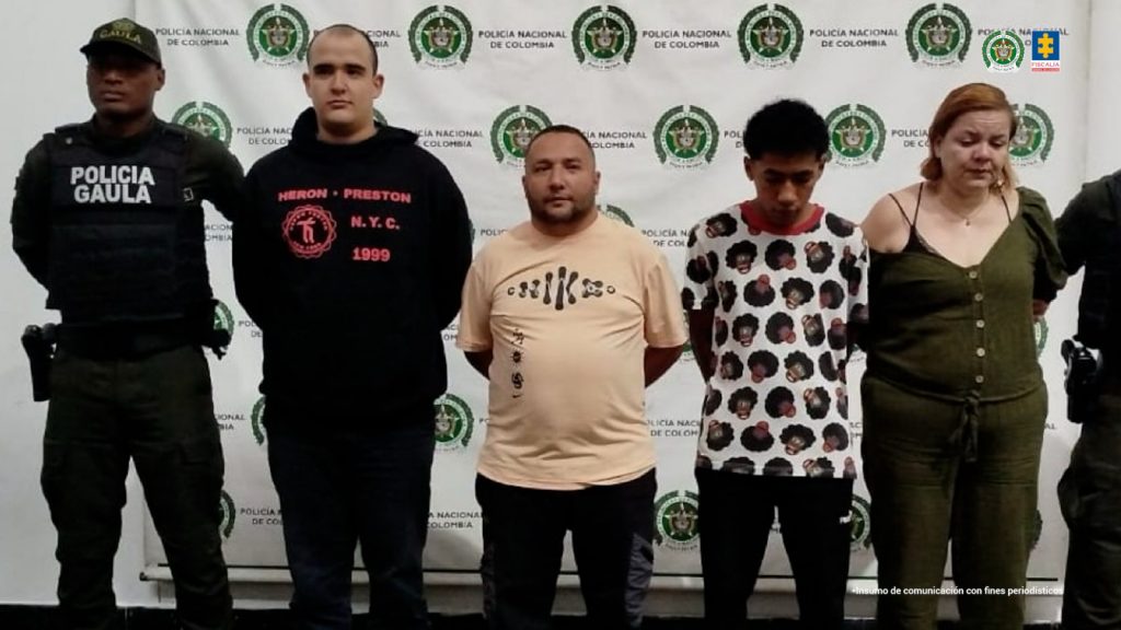 En la imagen están los 3 hombres y la mujer en medio de 2 servidores del Gaula de la Policía