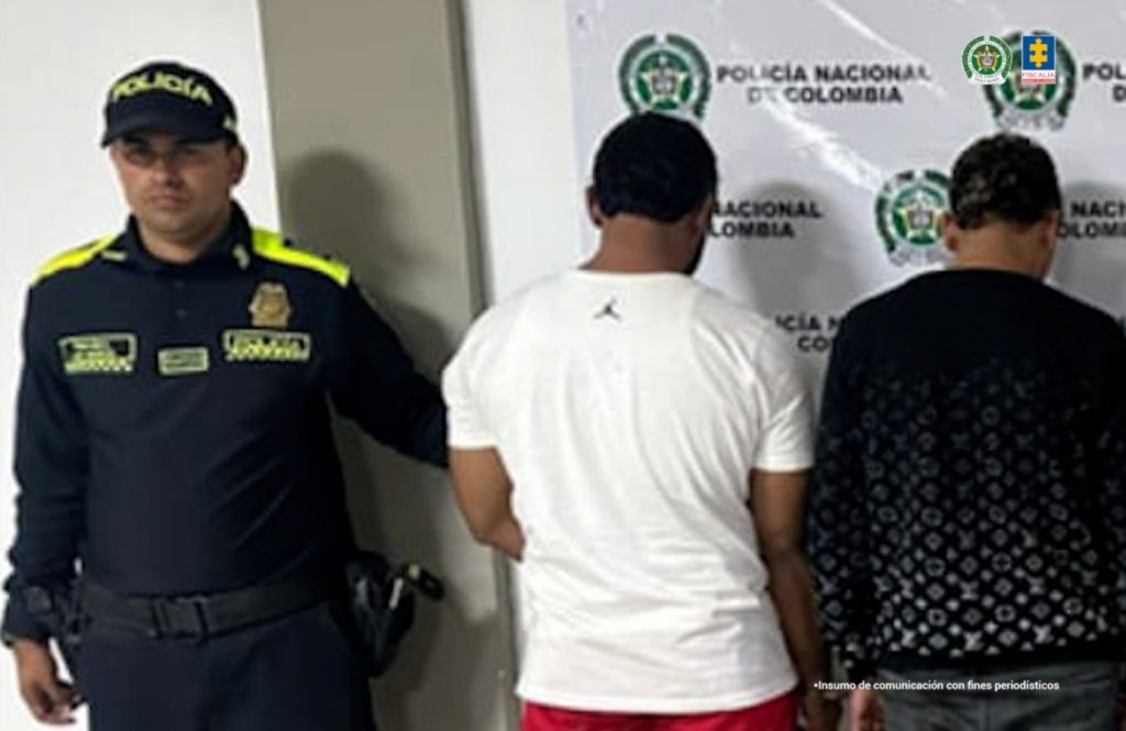 En la fotografía se aprecian de pie y de espaldas a la cámara Juan Steban Calle Lara y Gustavo Adolfo Calle. Uno viste camiseta de color blanco y pantalón rojo. El otro viste buso negro y pantalón gris. Al extremo izquierdo de ellos hay un uniformado de la Policía Nacional y en la parte posterior hay un pendón institucional de la Policía.