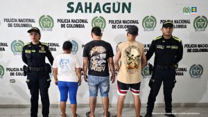 En la imagen aparecen tres personas, entre ellas una mujer, detenidas entre dos uniformados de la Policía Nacional.