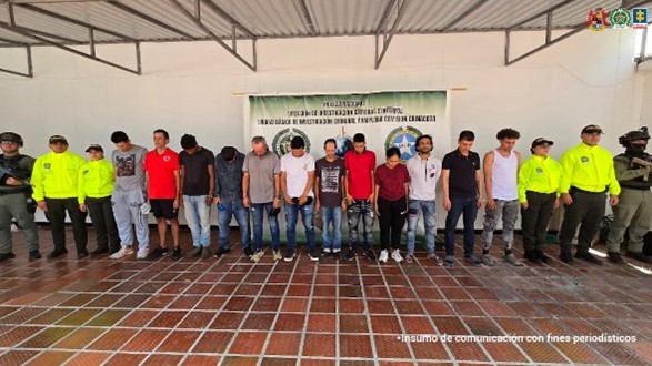 Se visualiza a los capturados junto a uniformados de la Policía Nacional. Detrás de ellos el banner que identifica a la Policía Nacional.
