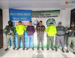 Se visualiza a los capturados junto a un investigador del CTI y uniformados de la Policía Nacional. Detrás de ellos los banners que identifica a la Policía y Ejército Nacional.