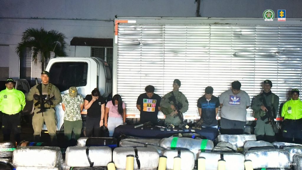 En la imagen aparecen los procesados en medio de varios uniformados de la Policía Nacional y al frente de ellos se aprecian varios bultos de la sustancia incautada.