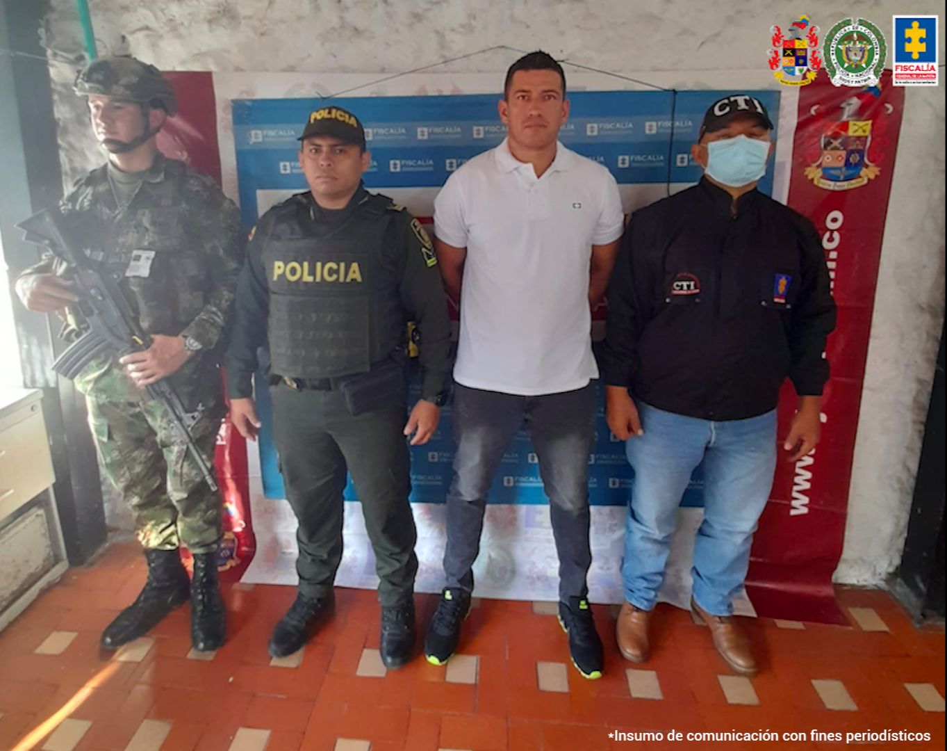 En la fotografía aparece un capturado, junto a personal Policía Nacional, Fiscalía General de La Nación y Ejército Nacional. En la parte posterior de la imagen se ven banners de Policía Nacional, Ejército Nacional y Fiscalía General de la Nación.