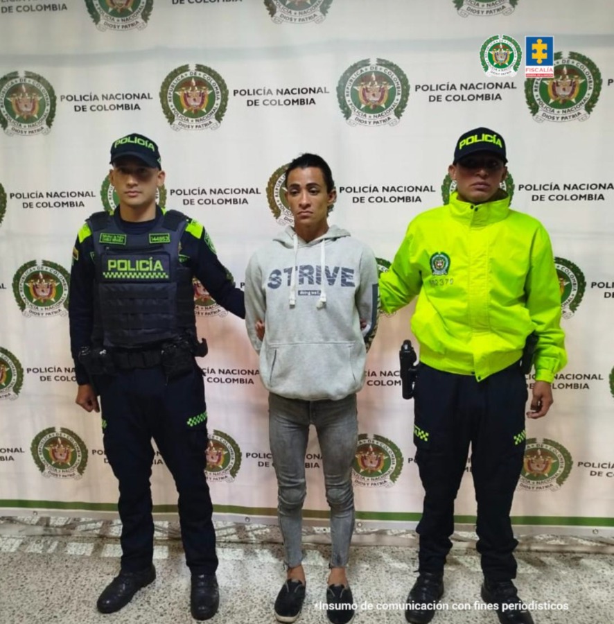 En la imagen aparece la procesada en medio de dos patrulleros de la Policía Nacional. y un baking de la misma entidad atras de ellos
