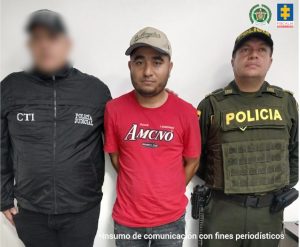 En la imagen aparece una persona de suéter rojo, entre un investigador del CTI y un uniformado de la Policía.