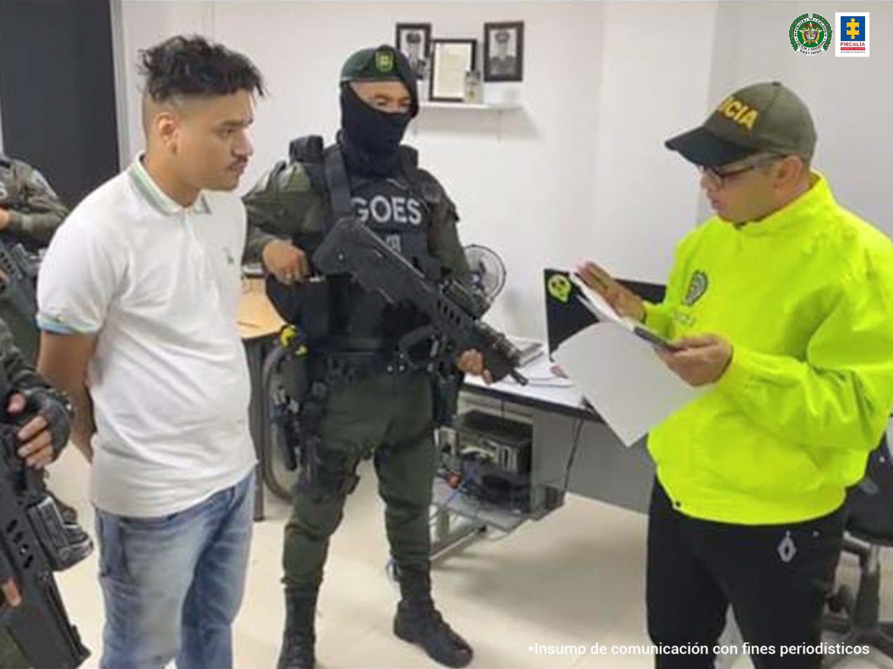 En la foto aparece, de pie y con los brazos atrás, Mauricio Alexander Mendoza Mejía, alias ‘La Chinga’ o ‘La Z’; viste camisa blanca de cuello y manga corta, jean azul. A lado y lado de él hay dos uniformados de la Policía Nacional. Frente a él hay otro uniformado de la Policía leyendo unos documentos.