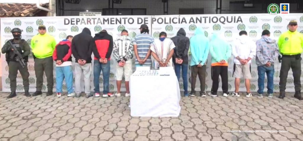 En la foto aparecen, de espaldas, los 11 presuntos delincuentes junto a una mesa con elementos incautados durante la captura.