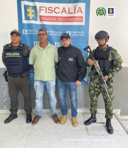 Un investigador del Cuerpo Técnico de Investigación (CTI), y uniformados de la Policía y Ejército Nacional custodian al procesado tras su captura en Barranquilla.
