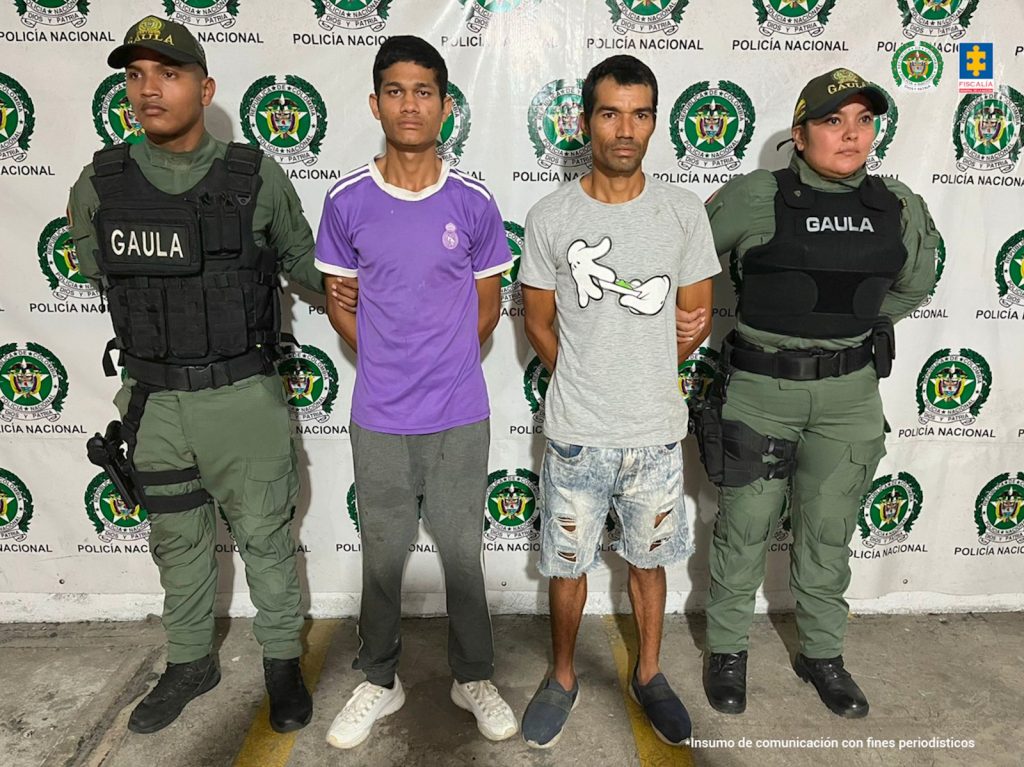 Los dos presuntos extorsionistas son custodiados por dos agentes de la Policía Nacional tras materializar su captura en flagrancia.