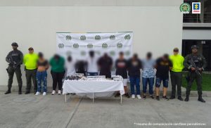 En la foto aparecen de pie presuntos integrantes de ‘La Platanera’. A los extremos de ellos hay uniformados de la Policía Nacional. Delante de ellos hay una mesa con mantel blanco y sobre ella hay armas de fuego, dinero en efectivo, munición y teléfonos celulares; asimismo los respectivos letreros alusivos a dichos elementos. En la parte posterior de los judicializados hay un pendón institucional de la Policía.