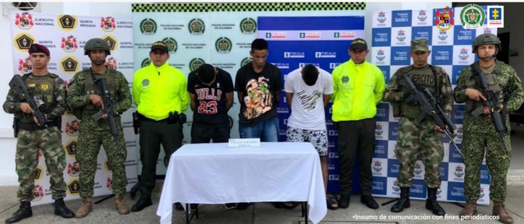 En la foto aparecen miembros de la Policía y Ejército custodiando a los tres capturados