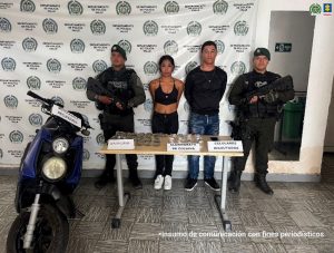 En la fotografía aparecen de pie y con los brazos atrás Laura Nicole y Róbinson Alexis Bedoya Londoño. La mujer viste con top negro, pantalón negro y zapatillas blancas. El hombre viste con camisa de manga larga y cuello redondo; jean azul desgastado y zapatillas negras. A sus extremos hay uniformados de la Policía Nacional. Delante de ellos hay una mesa y sobre ella se aprecian bolsas plásticas con contenido vegetal y blanco, así como un celular. Asimismo, hay tres letreros que dicen: ‘Marihuana’, ‘Clorhidrato de cocaína’ y ‘celulares incautados’. Detrás de ellos hay un pendón institucional de la Policía.