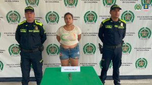 en la foto se aprecia a la hoy asegurada , siendo custodiada por dos policías. 