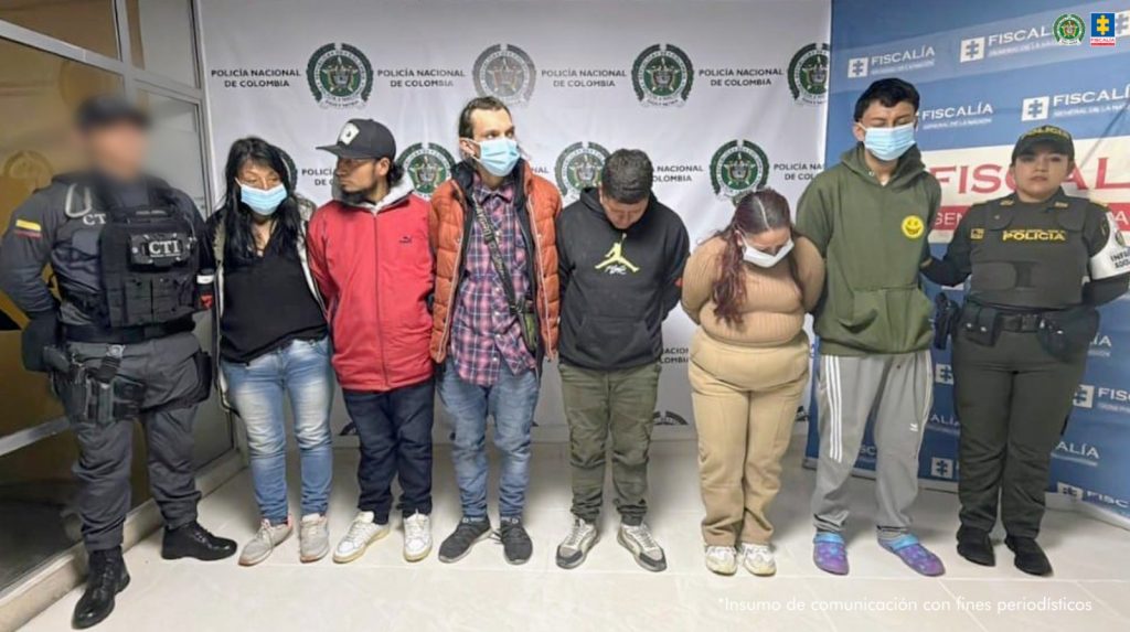 En la fotografía aparecen los seis detenidos junto a un servidor del CTI y una uniformada de la Policía. En la parte superior están un banner de la Fiscalía General y otro banner de la Policía.