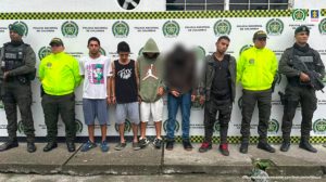 En la fotografía se aprecia a los presuntos integrantes de ‘Los Del Río’. A los extremos de ellos hay uniformados de la Policía. Detrás de ellos hay un pendón institucional de la Policía.