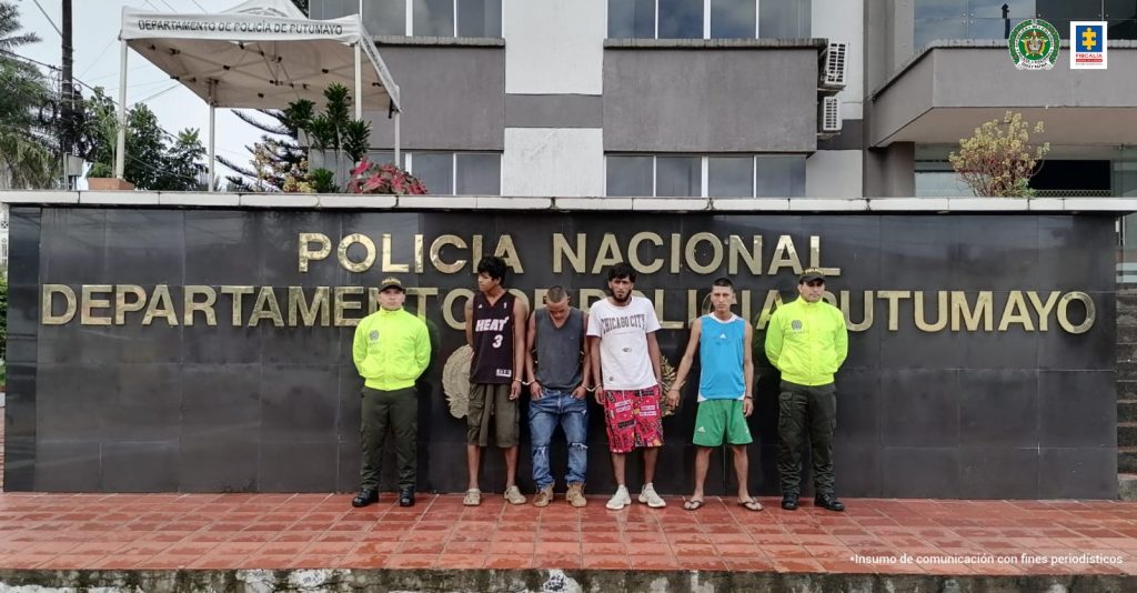 En la fotografía aparecen capturados junto a personal de Fiscalía Policía Nacional. En la parte posterior de la imagen se ven banners de Policía Nacional y la Fiscalía General de la Nación.