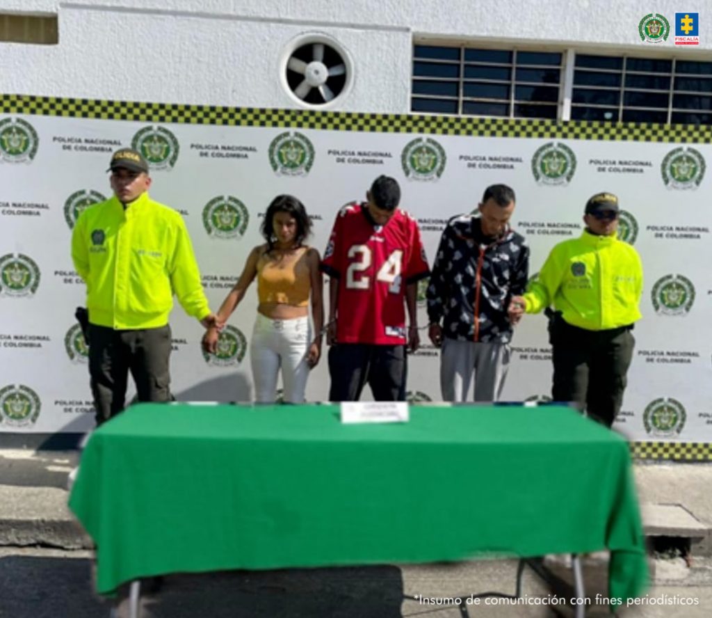 En la fotografía se aprecian de pie, en hilera y esposados a los tres presuntos integrantes de ‘Los Nocturnos’. Entre ellos hay una mujer. A sus extremos hay uniformados de la Policía Nacional. Delante de ellos hay una mesa con mantel verde. Detrás de ellos hay un pendón institucional de la Policía.